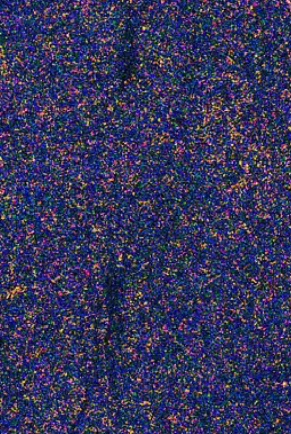 Close-up of a textured surface featuring a dense pattern of multicolored speckles primarily in blue, orange, and purple hues.